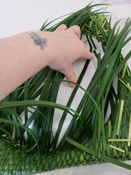 Fold blades of grass over the inside of the disk and glue down to follow the curve Fold blades of grass over the inside of the disk and glue down to follow the curve