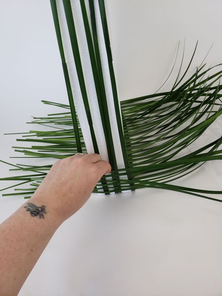 Let the grass rest on your working surface so that it stays in place as you add blades Let the grass rest on your working surface so that it stays in place as you add blades