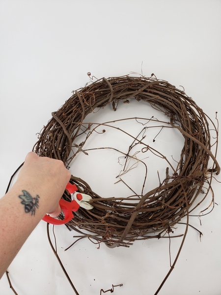 Place a circular grapevine wreath on a flat working surface Place a circular grapevine wreath on a flat working surface