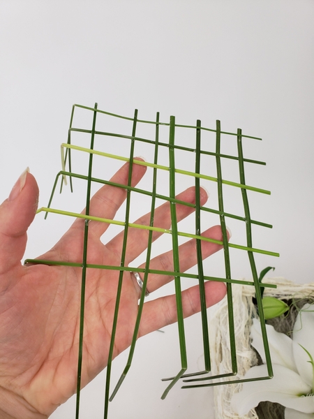 Fold the grass at the corners to extend down the box Fold the grass at the corners to extend down the box
