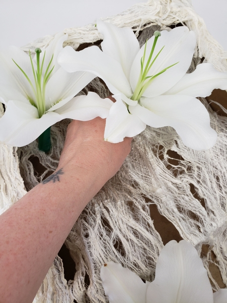 Place the flowers in water filled water tubes and glue the tubes to the bottom of the box