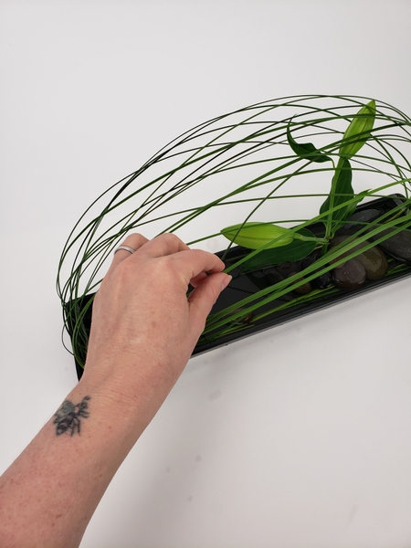 To create visual interest slip a few blades of grass through the loop and secure it under a rock just beyond the mid point To create visual interest slip a few blades of grass through the loop and secure it under a rock just beyond the mid point