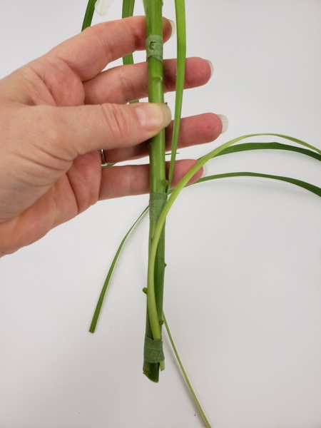 Bind a third blade of grass to the flower stem Bind a third blade of grass to the flower stem