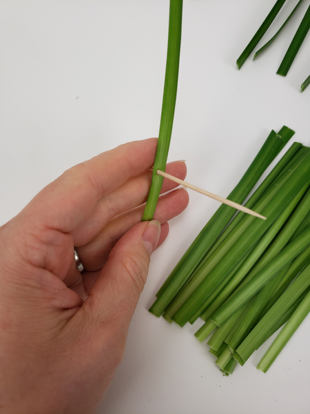 Make a hole in the grass with a sharp bamboo stick