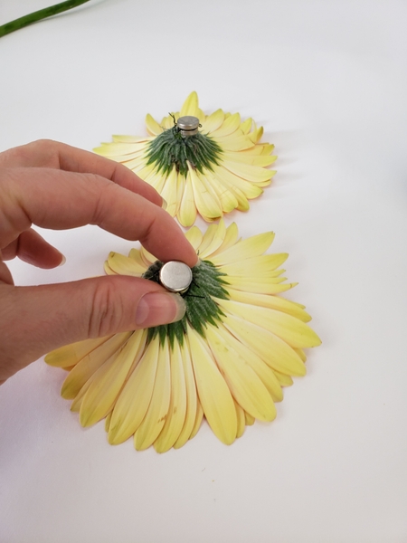 Tiny magnets keep the flowers in place under the water. Tiny magnets keep the flowers in place under the water.