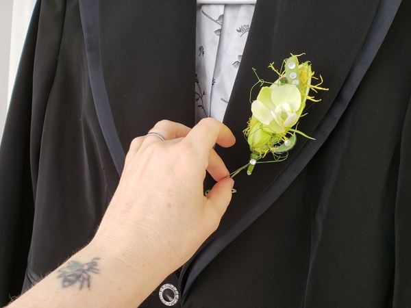 Place the corsage on the jacket lapel Place the corsage on the jacket lapel