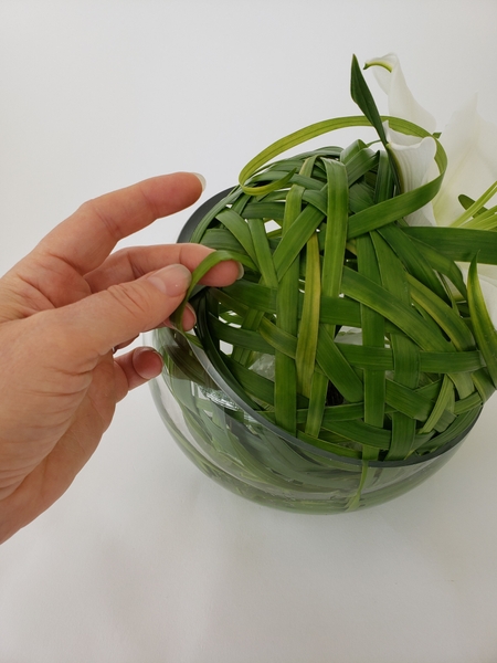 Weave the grass all the way around the ball so that it nestles into the water Weave the grass all the way around the ball so that it nestles into the water