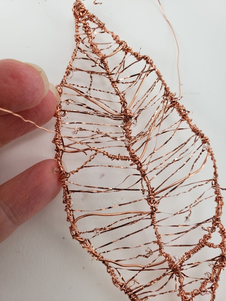 Finish the copper leaf by wrapping a few of the wires to create prominent veins Finish the copper leaf by wrapping a few of the wires to create prominent veins