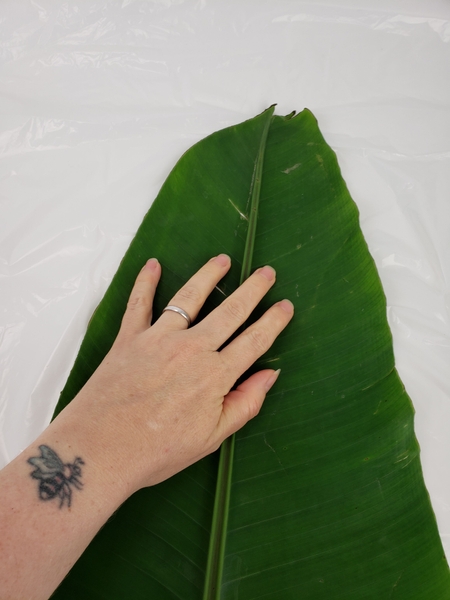 Place a large banana leaf on a flat working surface Place a large banana leaf on a flat working surface
