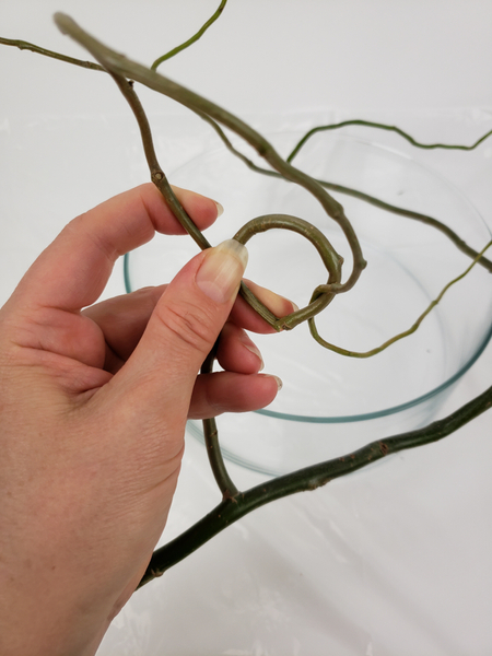 Slip the twig through the loop and start to weave