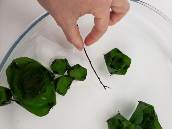 To finish my design I simply dropped twigs into the water to float along with the banana leaf flowers that I made To finish my design I simply dropped twigs into the water to float along with the banana leaf flowers that I made