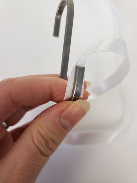 Glue a small line of hot glue in the inside curve of a butchers hook Glue a small line of hot glue in the inside curve of a butchers hook
