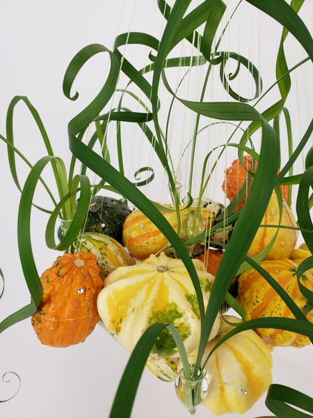 String up pumpkins to hang in a creative fall floral design