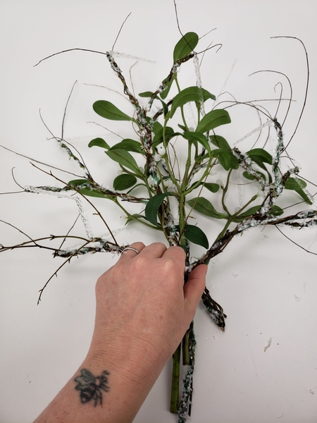 Build up the bunch by alternating between mistletoe and a wired branch Build up the bunch by alternating between mistletoe and a wired branch