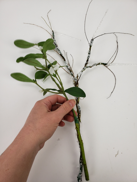 Place the stems on a flat surface and add the mistletoe