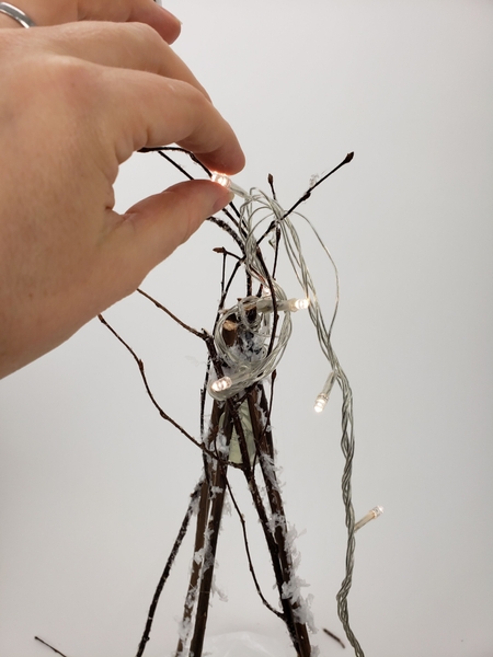 Create a controlled tangle by weaving the twigs through the wire Create a controlled tangle by weaving the twigs through the wire