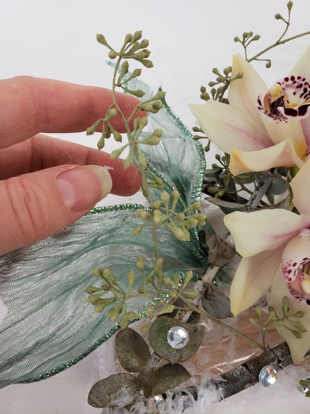 Fold a ribbon in half and add that to the design Fold a ribbon in half and add that to the design