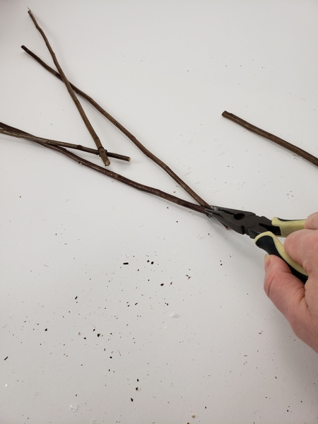 Wire the twigs together to create the triangular shape Wire the twigs together to create the triangular shape