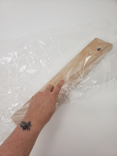 Wrap a piece of lumber in cellophane Wrap a piece of lumber in cellophane