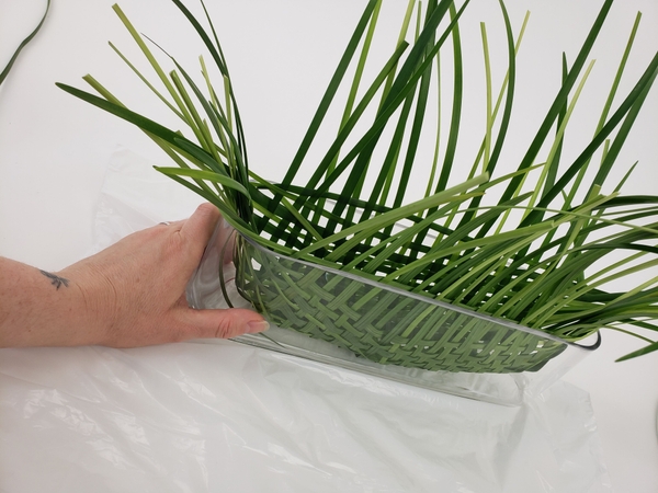 Gently curve the grass around the shape of the container to form the basket Gently curve the grass around the shape of the container to form the basket
