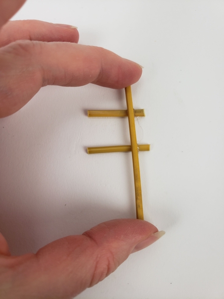 Glue in the next bamboo snippet to cross over the first Glue in the next bamboo snippet to cross over the first
