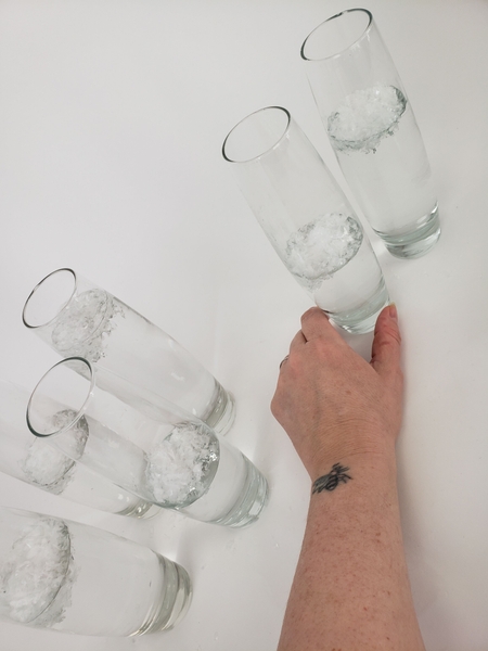Pour water into the bud vases so that the snow floats Pour water into the bud vases so that the snow floats