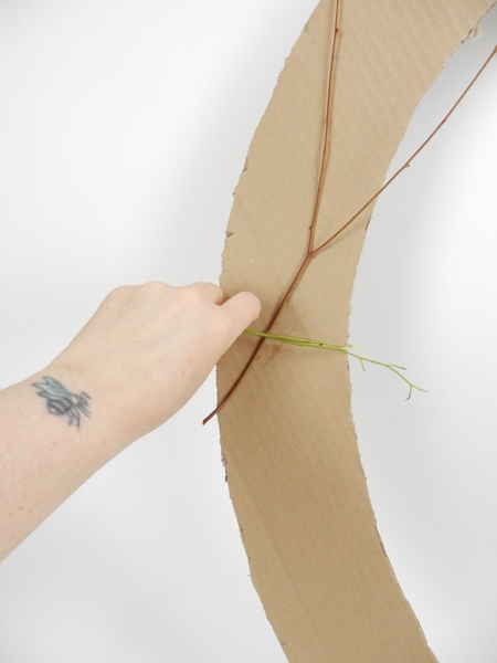 Wrap fresh eucalyptus stems around the cardboard Wrap fresh eucalyptus stems around the cardboard