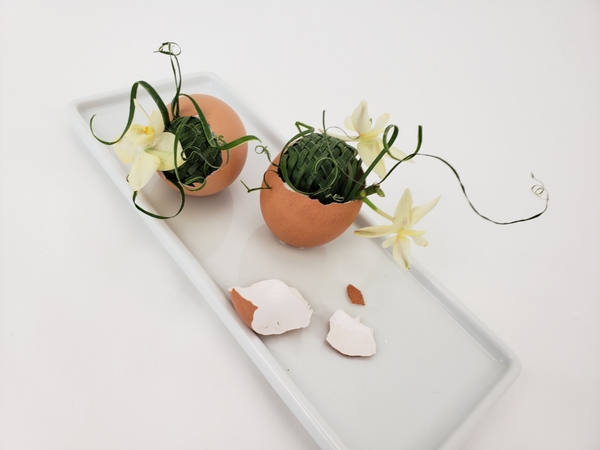 Arranging flowers inside an egg.