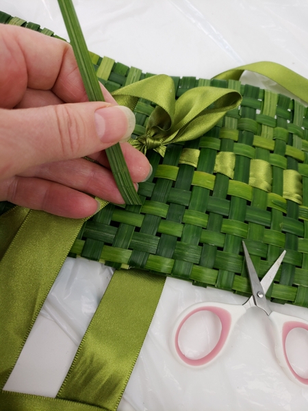 As a final step to secure the magnet weave a strand of grass around the purse