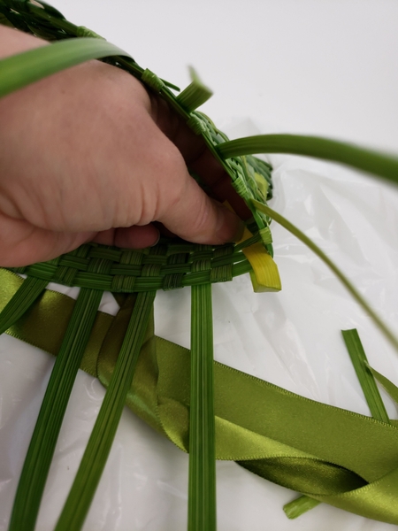 Begin in the corner and fold in the first strand of grass Begin in the corner and fold in the first strand of grass
