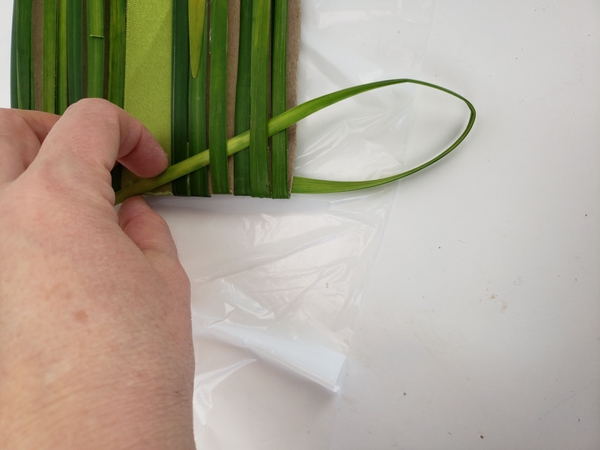 Bend the strand to the back and continue the weave. Bend the strand to the back and continue the weave.