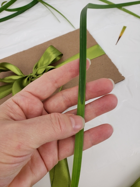 Connect strands of grass so that they wrap around the cardboard easily Connect strands of grass so that they wrap around the cardboard easily