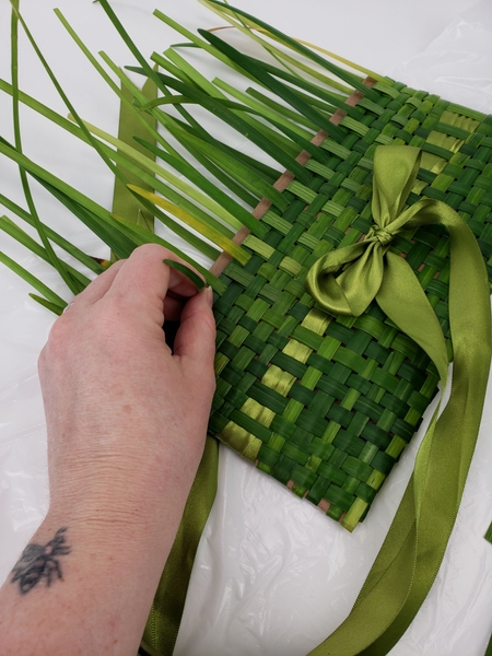 Move all the way around and weave in the grass strands Move all the way around and weave in the grass strands