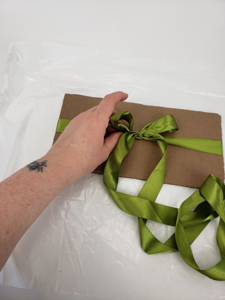 Tie a ribbon bow around the cardboard Tie a ribbon bow around the cardboard