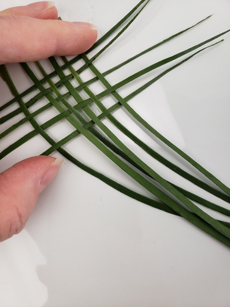 Weave a few blades of grass or palm to create a small basket weave Weave a few blades of grass or palm to create a small basket weave