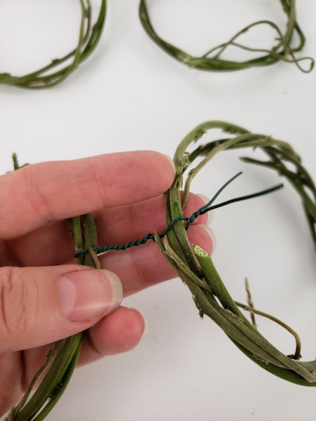 Extend the wire twist to the second wreath Extend the wire twist to the second wreath