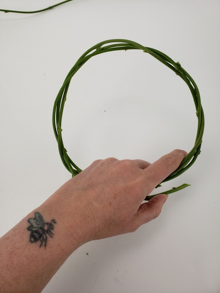Tuck the end of the stem into the wreath to secure it Tuck the end of the stem into the wreath to secure it