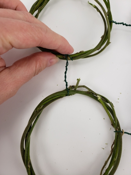 Twist the wire around the partner wreath and fold in the ends Twist the wire around the partner wreath and fold in the ends