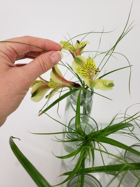 Slip an Inca lily stem through the papyrus. Slip an Inca lily stem through the papyrus.