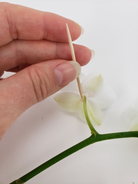 Apply the tiniest bit of glue to the flower Apply the tiniest bit of glue to the flower