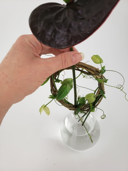 Place a heavy anthurium stem between the two wreaths Place a heavy anthurium stem between the two wreaths