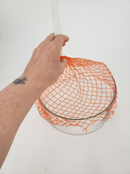 Wrap the net over the opening of a container